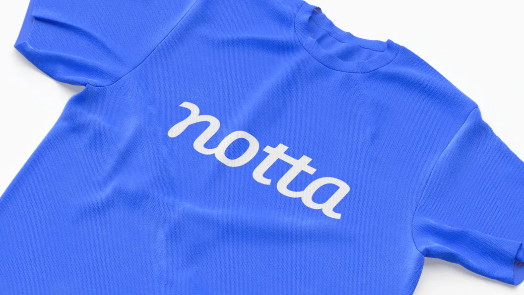 白いNottaのワードマークがプリントされた青いTシャツ