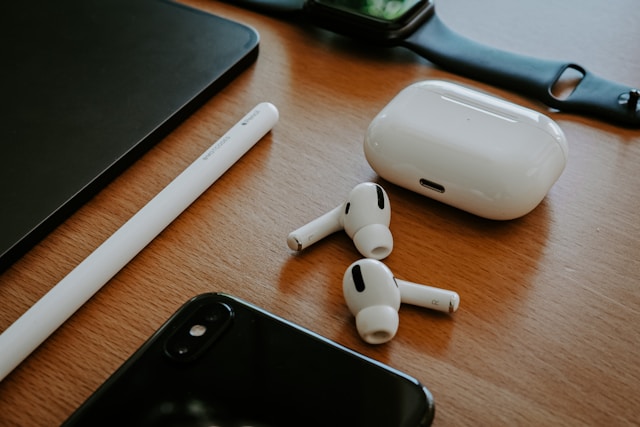 木製デスクの上に整然と並べられたAirPods Pro 3と充電ケース、Apple Pencil、Apple Watch、iPhone。Apple製品の連携イメージを伝えるシーン