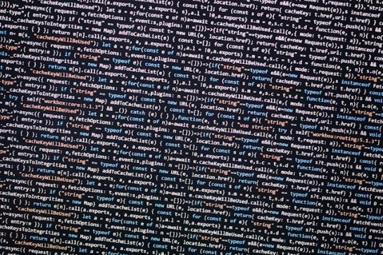 黒い画面いっぱいに英文や記号が並ぶプログラムコードのクローズアップテキストマイニングツールの背後で動くアルゴリズムや大量データの解析処理を象徴するイメージ