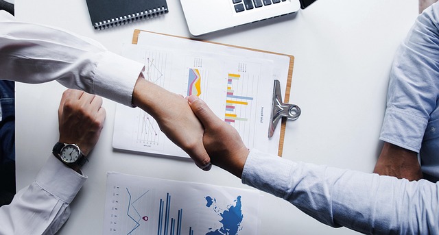 商談成立後に握手を交わすビジネスパーソン｜AIを活用した商談の振り返りと成約率向上のイメージ