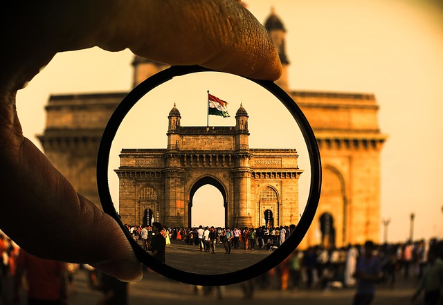 レンズを通してインド門と国旗を捉えた写真。タミル語翻訳アプリを使えば、インドの歴史的観光地をより深く理解できることを示唆しています。