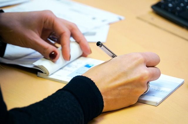 手帳に予定を書き込むビジネスパーソン|AI秘書アプリでタスク管理・リマインドを自動化(2025年版)