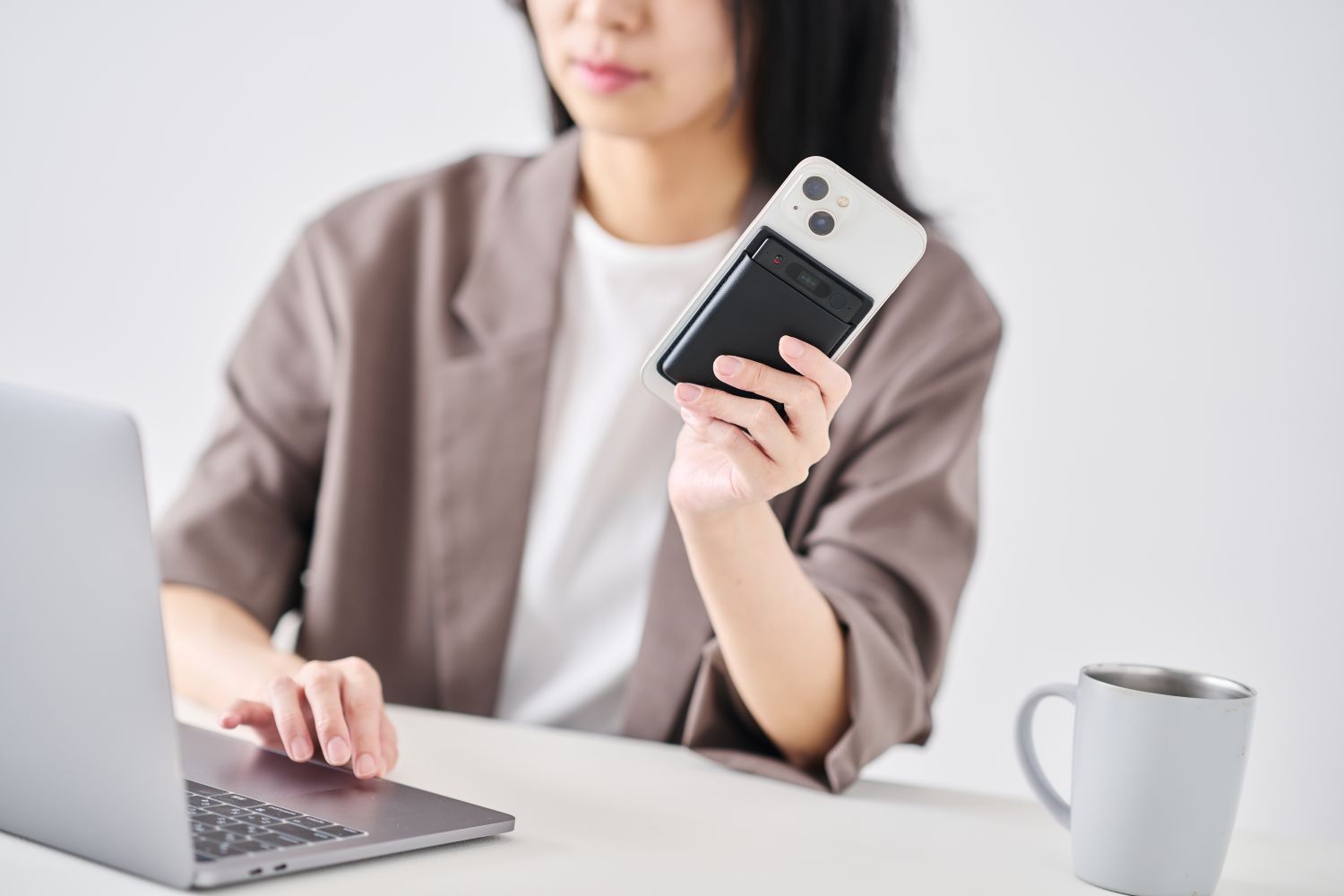 スマホの背面にNotta Memoが貼り付けられている。通話中の振動をセンサーでキャッチすうため、クリアな音質を実現。