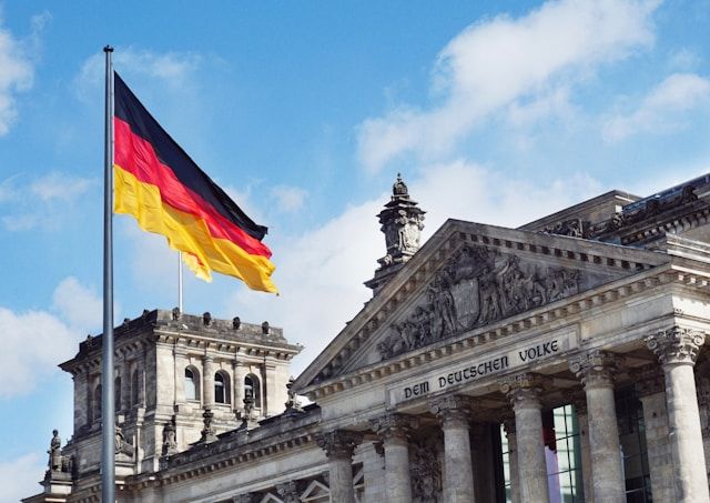 ベルリンの国会議事堂（ライヒスターク）と掲げられた国旗。ドイツ語の契約書や重要文書を翻訳する際に、文化的背景も理解する必要性を象徴している。