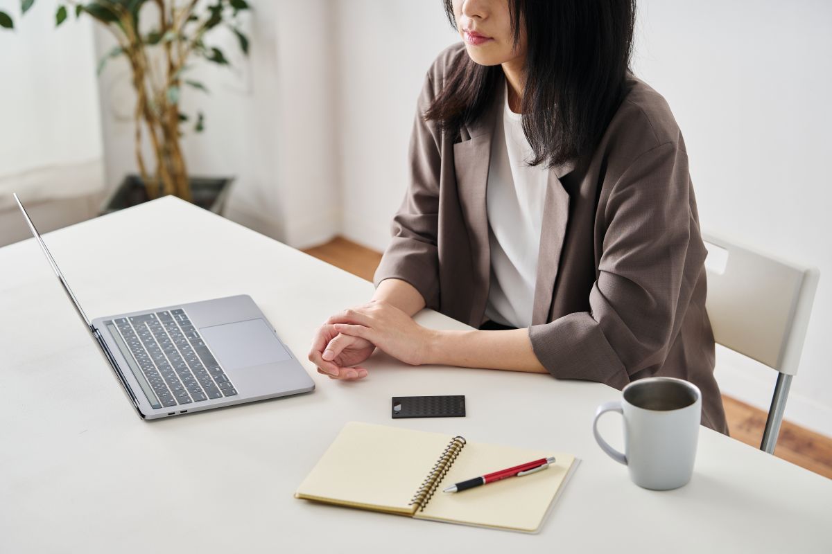 パソコンやノートがおかれたデスクに、Notta Memoがさりげなく置いてある。目立たないサイズ感のため、持ち運びにも便利。