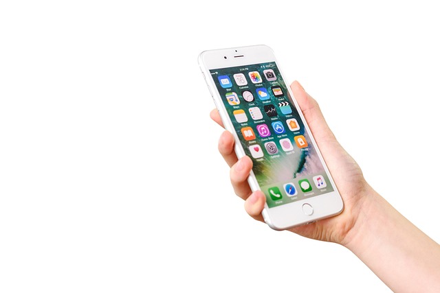 白い背景でiPhoneを手に持つ写真。スペイン語翻訳アプリをインストールして使うシーンのイメージに適しています。