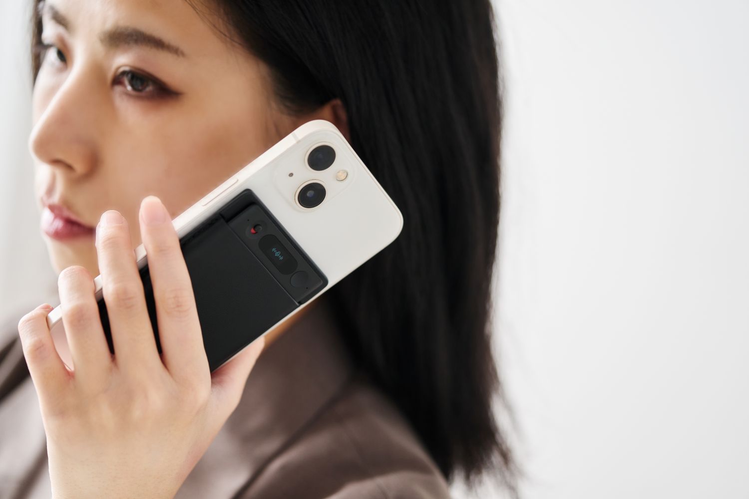 女性がNotta Memowo搭載したスマホで通話を録音している。骨伝導マイクのためクリアな音質。