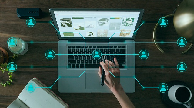 ノートパソコンの画面をタッチペンで操作し、ネットワーク上に複数のユーザーアイコンが接続されているイメージ。NottaのようなAIツールを活用した国際的なビジネスコミュニケーションを象徴する。