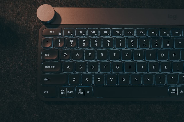 薄暗い背景で光るモダンなキーボード。Cursor 2.0の新機能や効率的なコーディング環境を示唆。